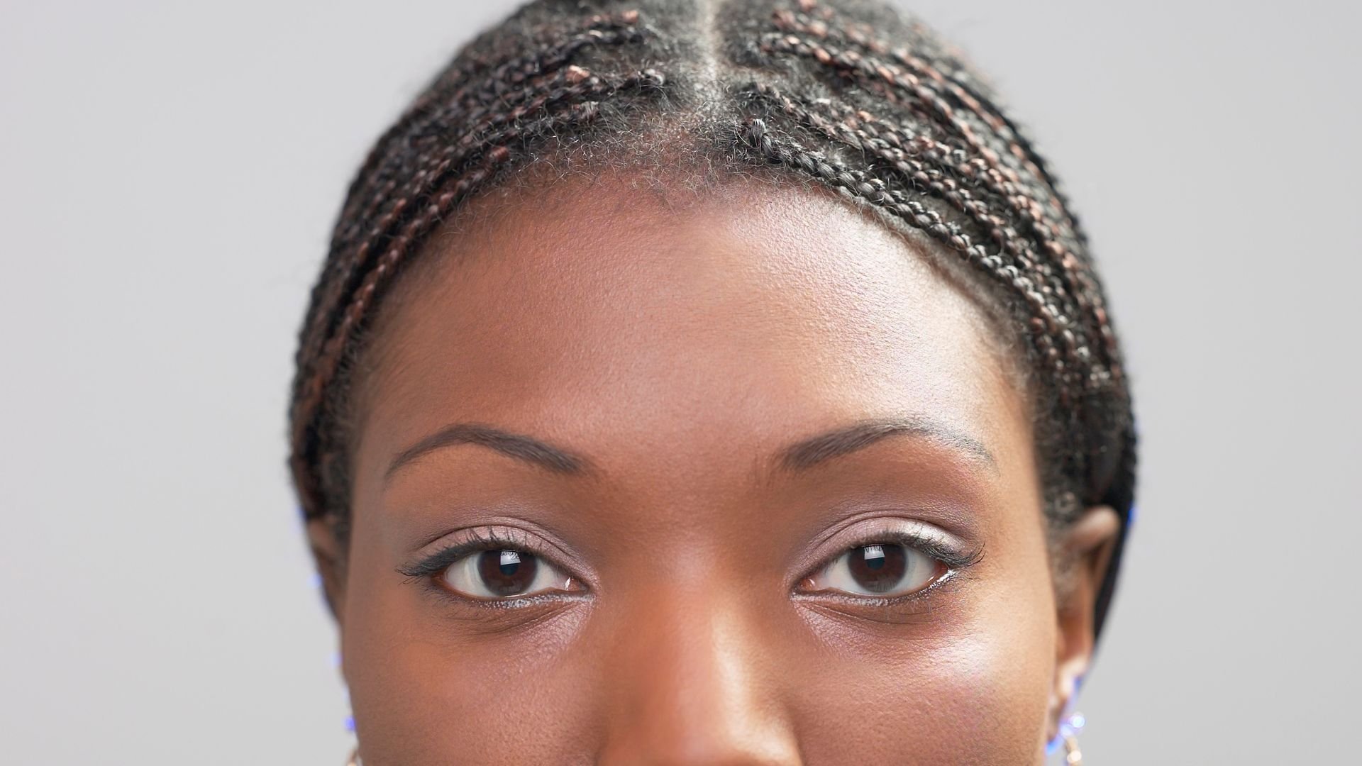 Close-up of eyes with braided hair and subtle makeup